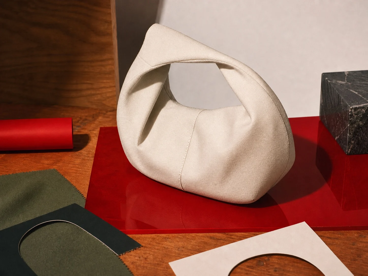 Cream handbag on red acrylic with fabric and paper references